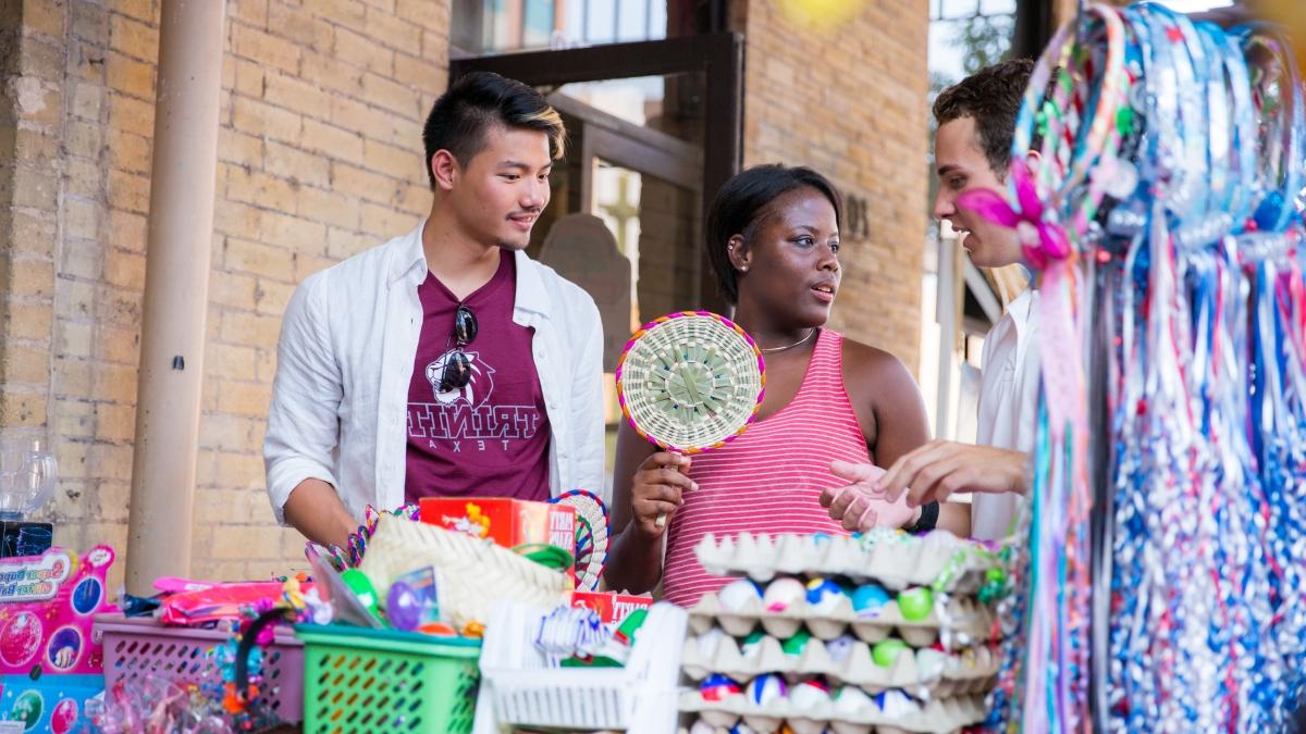 three students shop for trinkets in historic market square